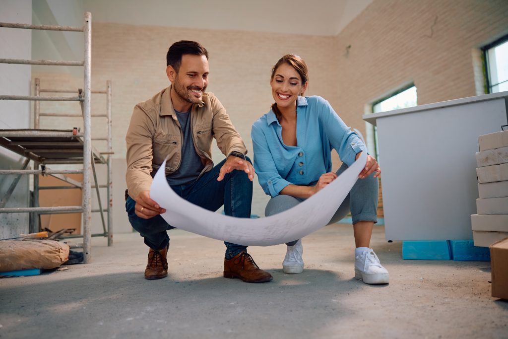 Pareja revisando planos en obra de construcción para decidir si comprar o construir casa en Mexicali